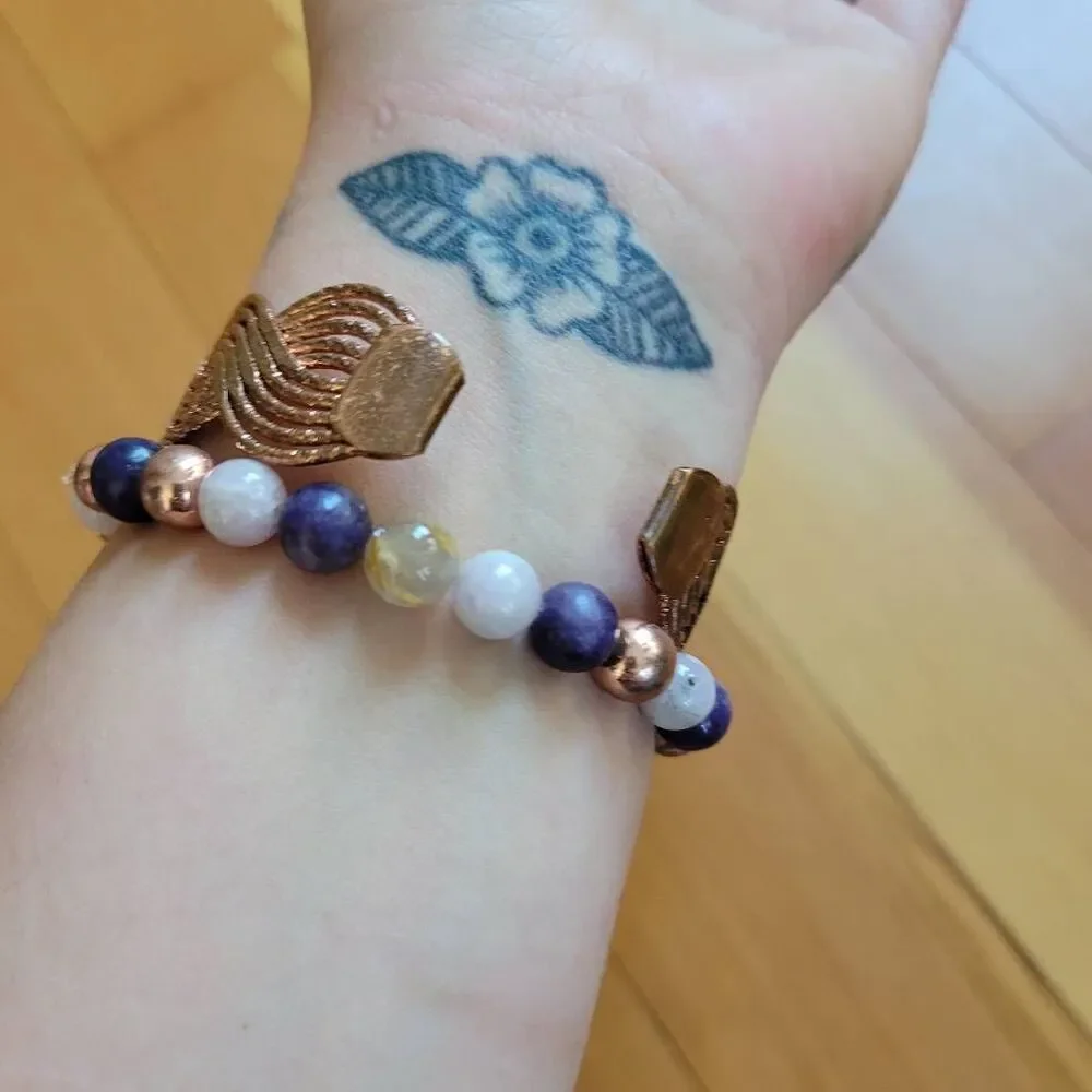 Set of two bracelets copper colored wavy bangle and stretchy beaded multicolored